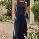 Woman in a navy dress standing in a garden setting