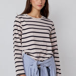 Woman wearing a striped sweater and blue jeans with a white background