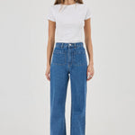 Woman wearing a white t-shirt and blue jeans on a white background