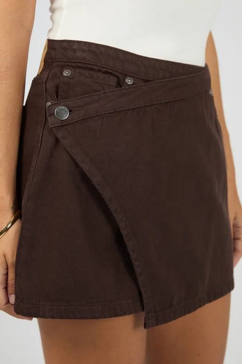 Brown skirt worn by a person on a plain background