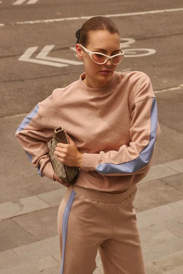 model wears brown with blue stripe sweatshirt