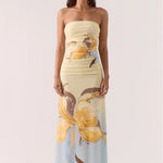 Woman wearing a strapless dress with a floral pattern on a white background