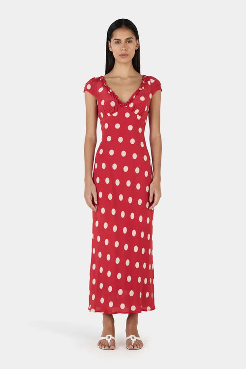 Woman wearing a red polka dot dress on a white background