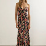 Woman wearing a floral dress against a plain background