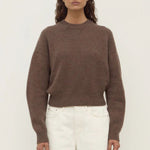 woman wears a brown knit cardigan