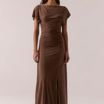 Woman wearing a brown dress with a plain background