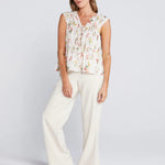 woman wearing a cream floral top and cream pants