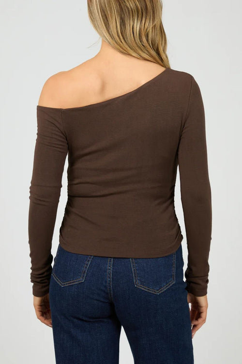 Brown one-shoulder long-sleeve top worn by a person on a white background