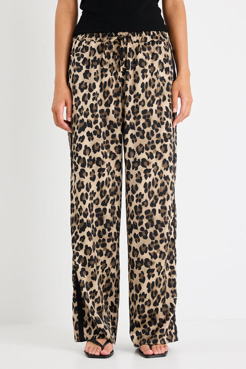 Leopard print pants worn by a person on a white background