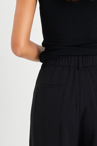 Woman wearing a black jumpsuit on a white background