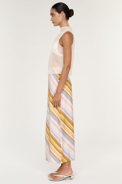 Woman wearing a sleeveless top and striped skirt on a white background
