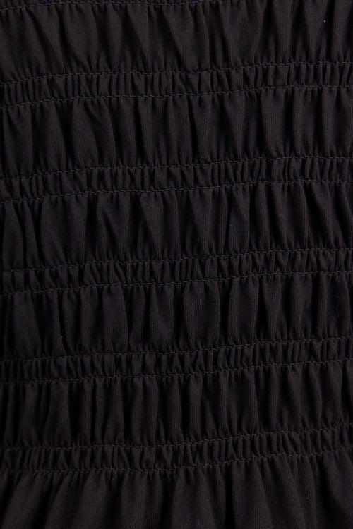 Close-up of a black smocked fabric with horizontal gathered stitching.