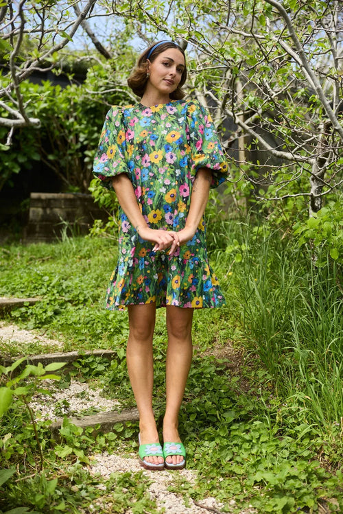 Woman in a floral dress standing in a garden