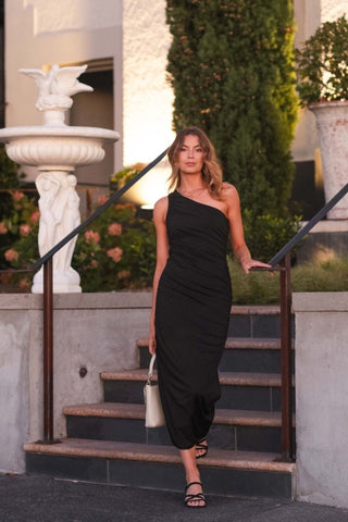 model wears a one shoulder black midi dress