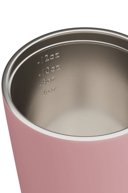 Close-up of a pink tumbler with a metallic interior and measurement markings.