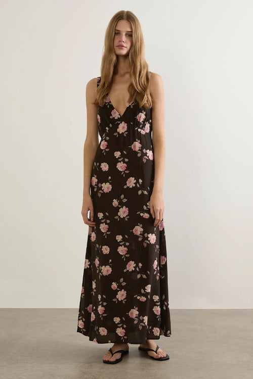 Woman wearing a floral dress against a plain background