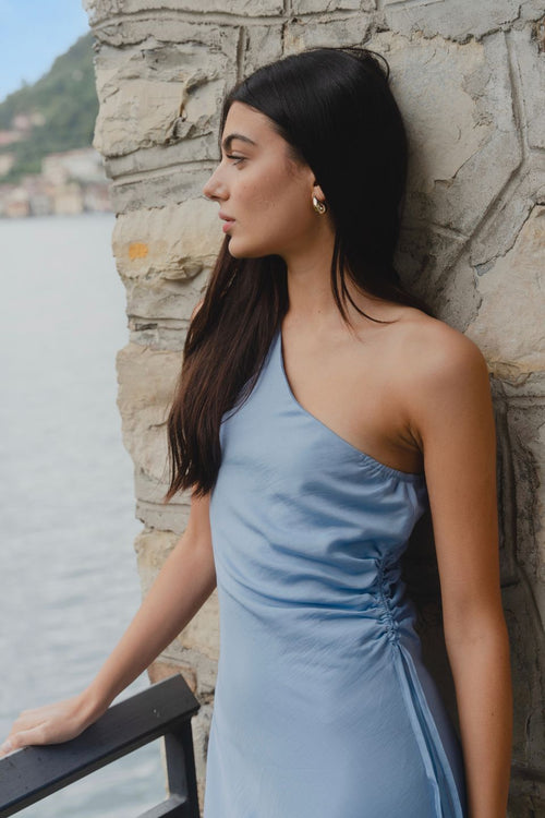 model wears a blue one shoulder midi dress