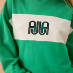 green and white sweater with text on front