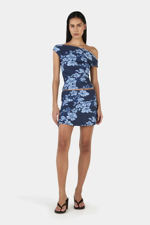 Woman wears a navy blue floral top and skirt