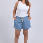 Woman wearing chambray denim shorts and white tank