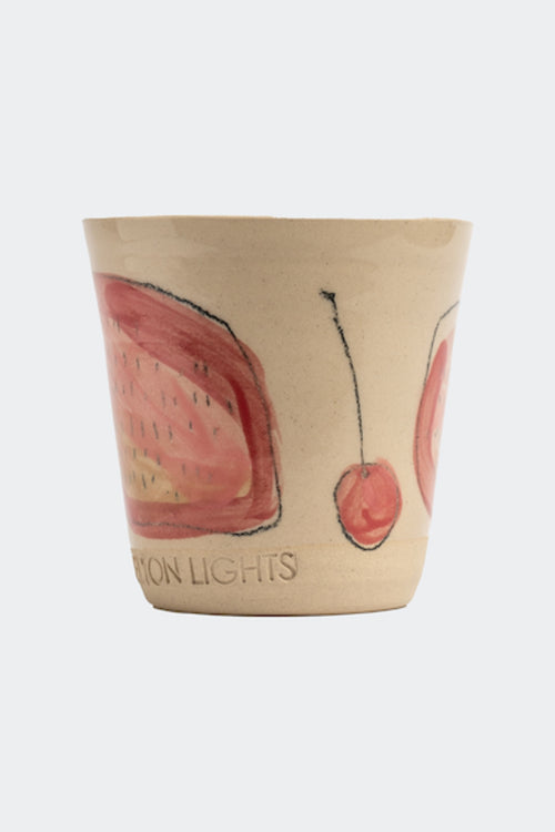 Candle in a ceramic cup with cherry design on a white background