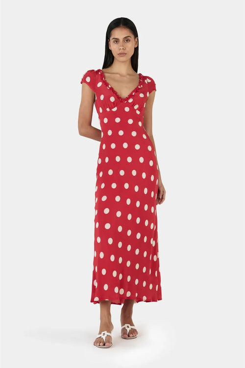 Woman wearing a red polka dot dress on a white background