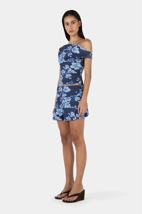 Woman wears a navy blue floral top and skirt