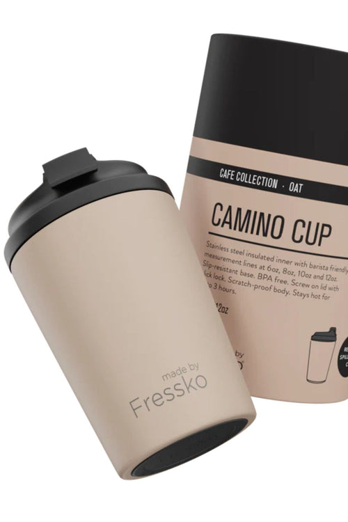 Beige Camino Cup with black lid and packaging on a white background