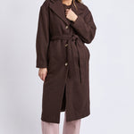 Woman wearing a brown coat on a white background