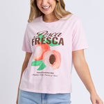 Woman wears a pink printed top and blue shorts