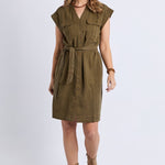 Woman wearing a green dress with a belt on a white background