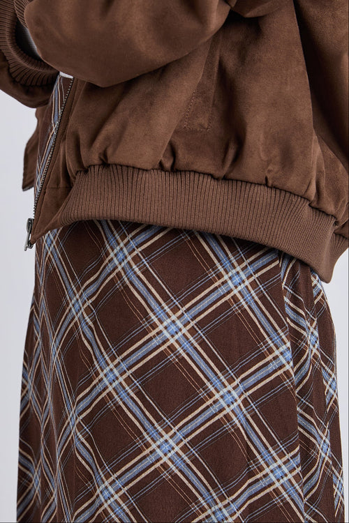 Brown jacket over a plaid skirt on a white background