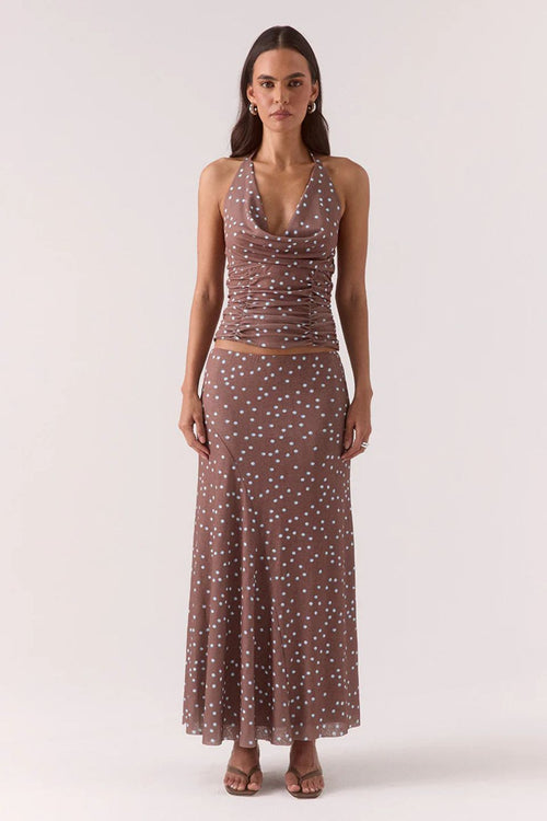 Woman wearing a brown and blue polka dot skirt and top set 