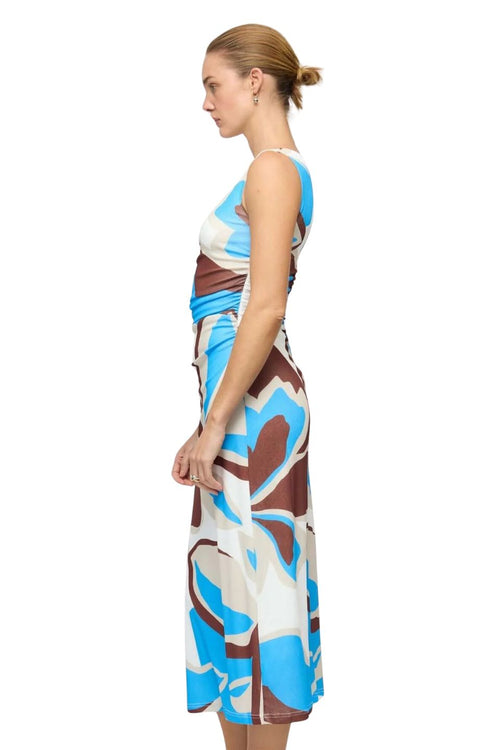 Woman wearing a colorful dress with abstract pattern on a white background