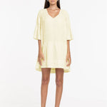 Woman wearing a light yellow dress on a white background