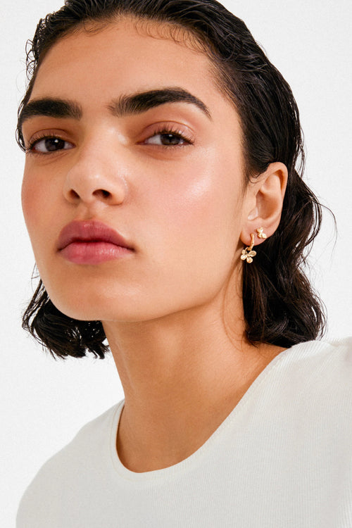 Woman wearing a white top with a plain background