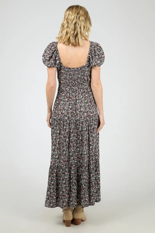 Woman wearing a dark purple floral maxi dress