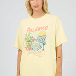 Woman wearing a yellow t-shirt with a graphic design on a plain background