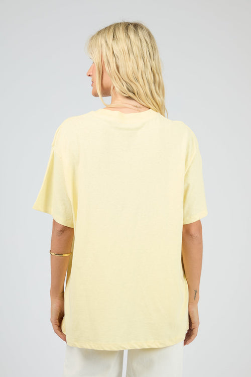 Person wearing a light yellow t-shirt on a plain background