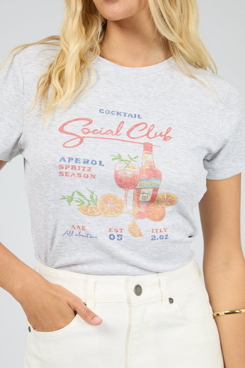 Person wearing a gray t-shirt with a colorful graphic and text on a plain background