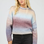 Woman wearing a multicolored sweater against a plain background