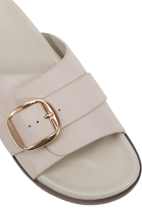 Beige sandal with a gold buckle on a white background
