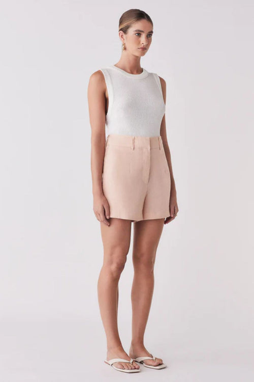 Woman wearing pink shorts and a white tank top