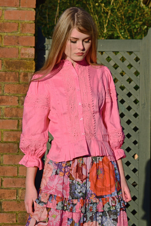 Model wears a pink blouse