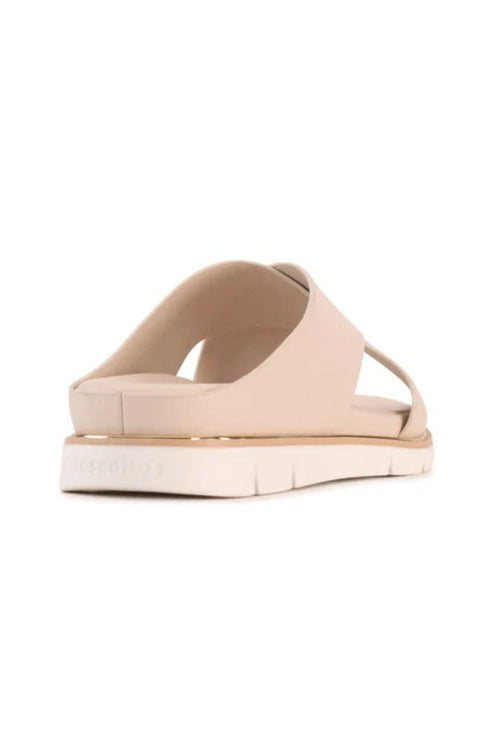 A single platform slide sandal in a light beige or nude color, shown from a side profile view against a plain white background.
