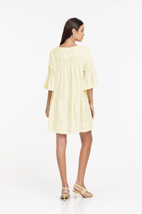 Woman wearing a light yellow dress on a white background