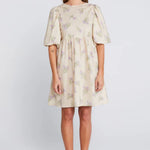 Woman wearing a cream floral mini dress with puff sleeves