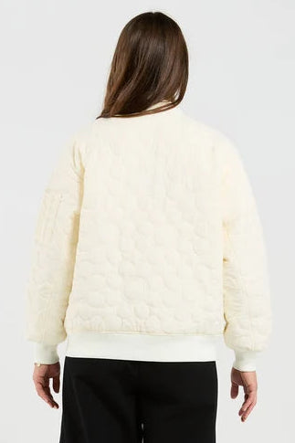 Person wearing a light-colored sweater and black pants on a white background