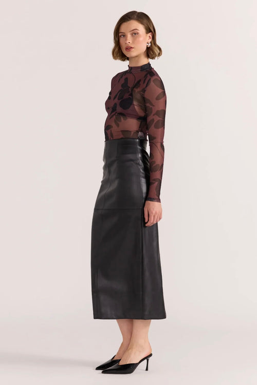 model wears a black leather midi skirt 