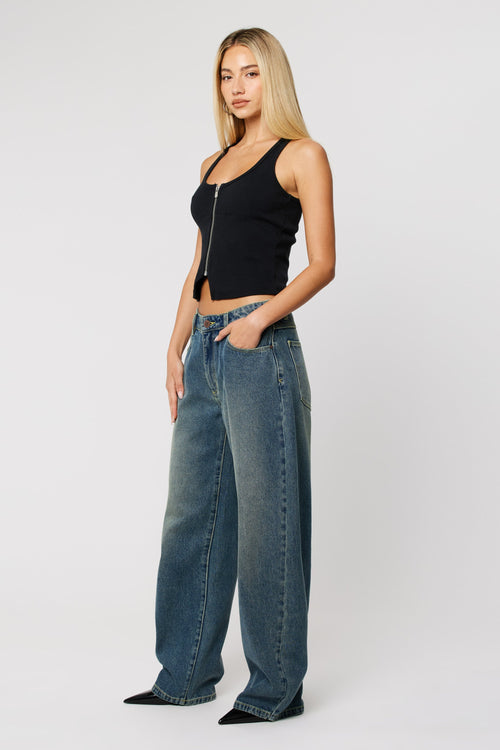 Woman wearing dark wash denim blue jeans with wide leg 